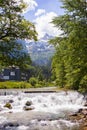 A small waterfall in the village against the backdrop of the Alps Royalty Free Stock Photo