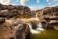 Small waterfall of water flowing over rocks in Sam-Pan-Bok Grand Canyon, Thailand Royalty Free Stock Photo