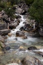 A small waterfall. Water stream passing through big rocks. Mountain steam. Royalty Free Stock Photo