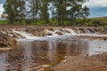 Small waterfalls produced by the rain in the red river Royalty Free Stock Photo