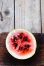 Small watermelon cut on a wooden background