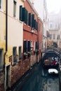 Small waterways of Venice. River canal with old brick medieval buildings in foggy day, Italy. Typical boat Royalty Free Stock Photo