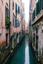 Small waterways of Venice. River canal with old colorful buildings in foggy day, Italy. Typical boat transportation Royalty Free Stock Photo