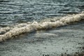 A small wave breaking on a beach near Dublin, Ireland Royalty Free Stock Photo