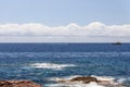 Small waves on sea surface and small white motorboat crosses the bay in distance, Ibiza, Balearic Islands, Spain Royalty Free Stock Photo