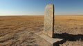 small weathered altar stands isolated in vast golden desert marked faint inscriptions. wind carries whispers of ancient