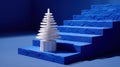 A small white artificial Christmas tree on a blue textured staircase, illuminated by soft lighting, in a minimalist and modern Royalty Free Stock Photo