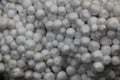 Small white balls of styrofoam on grass with twigs and leaves