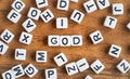 Small white and black bead cubes on wooden board, letters in middle spell GOD, religion concept Royalty Free Stock Photo