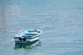 Small white blue boat with paddles anchored on the shore Royalty Free Stock Photo