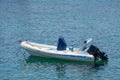 Small white blue motorized boat anchored on the shore