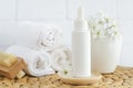 Small white bottle with essential oil (perfume, essence, cosmetic serum), skin care, spa and herbal