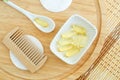 Small white bowl with cosmetic oil face serum, cod fish oil capsules, cotton pads and wooden hair brush. Natural spa, skin care Royalty Free Stock Photo