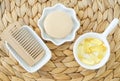 Small white bowl with cosmetic oil face serum, cod fish oil capsules, bar of soap solid shampoo and wooden hair beard brush. Royalty Free Stock Photo