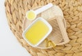 Small white bowl with honey, softgel capsules and wooden hairbrush. Natural skin and hair care, homemade spa and beauty treatment