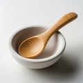 A small white ceramic bowl with a smooth matte finish holds a bamboo spoon Royalty Free Stock Photo
