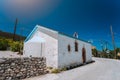 A small white chalk Greek Orthodox chapel in countryside on the narrow winding road Royalty Free Stock Photo