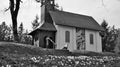 Small white chapel on a hill behind white flowers with bokehe effect in black and white Royalty Free Stock Photo