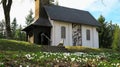 Small white chapel on hill behind white flowers Royalty Free Stock Photo