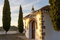 Small white stone chapel on a hill surrounded with cypress trees under cloudy morning sky Royalty Free Stock Photo