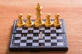 A small white chess pieces against very big gold chess team on b Royalty Free Stock Photo