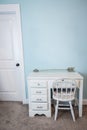 A small white child's desk and chair in a pale blue bedroom in a new construction house Royalty Free Stock Photo