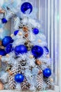 Small white Christmas tree decorated with blue balls and cones Royalty Free Stock Photo