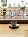 Small white coffee cup in cafe in front of window