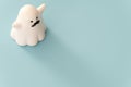 Small white color plastic ghost figure in blue background view