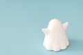 Small white color plastic ghost figure in blue background view