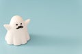 Small white color plastic ghost figure in blue background view