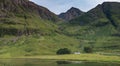 Small white cottage below magnificent mountains next to Loch Achtriochtan ,Glencoe,Scotland,UK Royalty Free Stock Photo