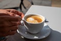 Small white cup of black arabica coffee served outdoor