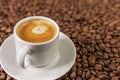 A small white cup of coffee stands on coffee beans. Fragrant pleasure. Background. Space for text. Close-up Royalty Free Stock Photo