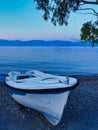 Small White Fishing Boat on Pebble Beach at dawn, Greece Royalty Free Stock Photo