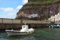 A small white fishing boat in the old port of the Greek city of Fira. Royalty Free Stock Photo