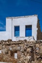 Small white house with blue color door and window, wooden frames on whitewashed  wall, greek island architecture, clear blue sky Royalty Free Stock Photo