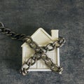 Small white house and a decorative chain on a dark background. C