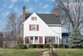 Small White House with Sloping Roofline and Red Shutters