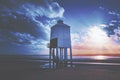 Small white lighthouse on the seaside at sunset Royalty Free Stock Photo