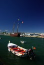 A small white motor boat with a portuguese flag, anchored at a harbor Royalty Free Stock Photo