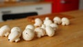 Close up of mushrooms on kitchen table. Small white mushrooms scattered on table in kitchen. Royalty Free Stock Photo