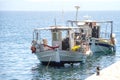 Small white overloaded fishing boat anchored next to the dock Royalty Free Stock Photo