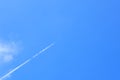 Small white plane with white smoke trail on the blue sky. Royalty Free Stock Photo