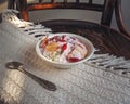 A small white plate with cottage cheese and sliced fruit stands on a vintage chair Royalty Free Stock Photo