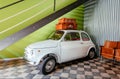 Small white retro car inside house, ready for travel