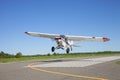 Small white single engine airplane takes off from a municipal airstrip in rural Minnesota