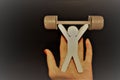 A small toy man holds a barbell with his hands up