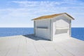 Small white wooden cottage with thatched roof by the sea - image with copy space Royalty Free Stock Photo