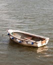 Small white wooden row boat moored on river surface Royalty Free Stock Photo